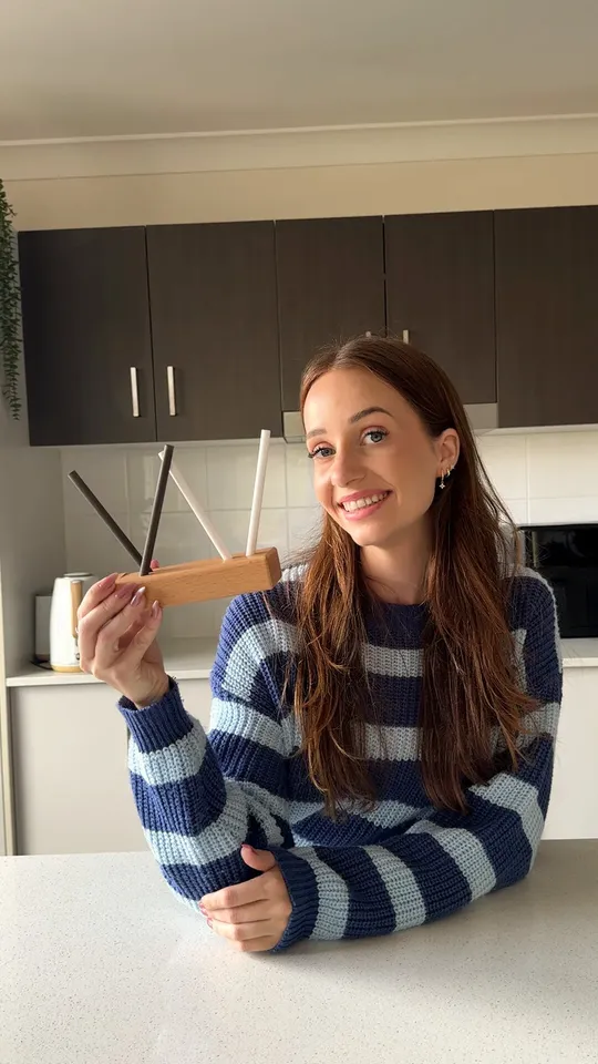 Creator holding a knife sharpener up to camera in her kitchen