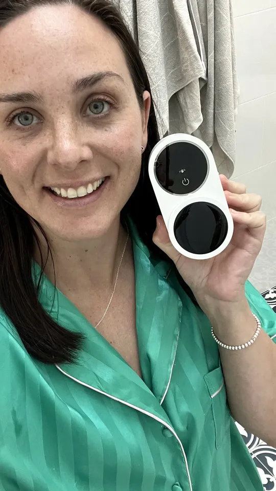 Creator smiling with a toothbrush steriliser in her bathroom